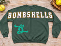 Forest green Bombshells softball crewneck sweatshirt back print with large white letters outlined gold and teal B emblem