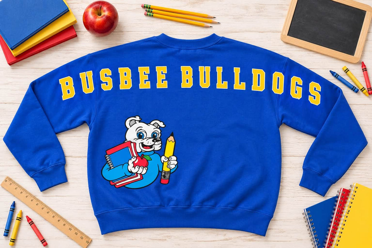 Royal blue Busbee Bulldogs sweatshirt with oversized yellow back lettering and bulldog mascot holding school supplies