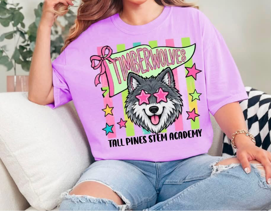 Purple Tall Pines STEM Academy Timberwolves tee with a wolf in pink star glasses, a bow, colorful stripes, and stars